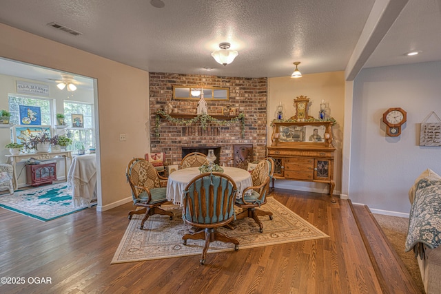 4430 E 26th St, Joplin, MO 64804 - dining space featuring a textured ceiling, wood finished floors, a fireplace, and baseboards