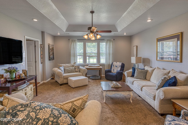 4430 E 26th St, Joplin, MO 64804 - living room featuring a raised ceiling, a textured ceiling, carpet, a ceiling fan, and baseboards