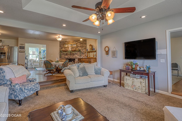 4430 E 26th St, Joplin, MO 64804 - carpeted living room featuring a ceiling fan, baseboards, a brick fireplace, recessed lighting, and wood finished floors