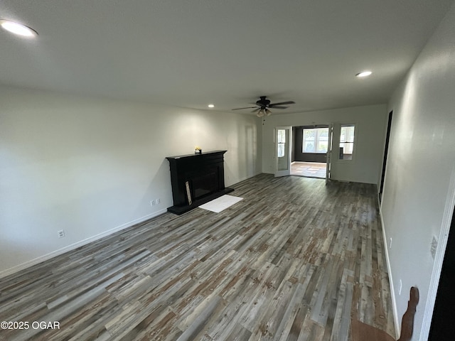 1910 Carolina Ave, Joplin, MO 64801 - unfurnished living room with wood finished floors, a ceiling fan, recessed lighting, a fireplace with raised hearth, and baseboards