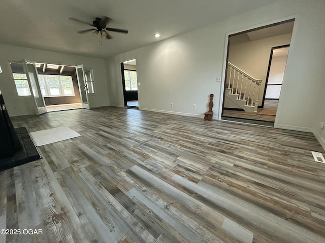1910 Carolina Ave, Joplin, MO 64801 - unfurnished living room with wood finished floors, stairs, a ceiling fan, baseboards, and recessed lighting