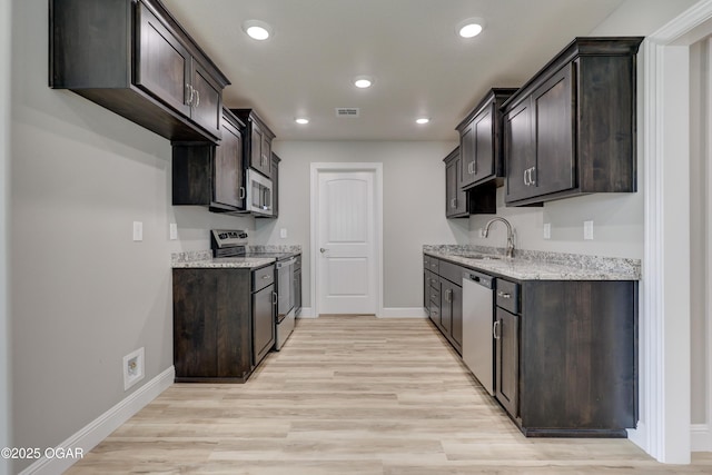 1919 Wisconsin Ave, Joplin, MO 64804 - kitchen featuring stainless steel appliances, dark brown cabinets, light stone counters, light wood-style flooring, and recessed lighting