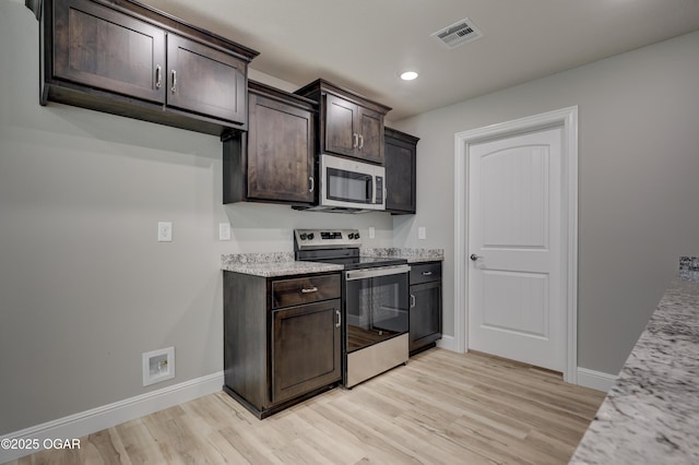 1919 Wisconsin Ave, Joplin, MO 64804 - kitchen featuring appliances with stainless steel finishes, dark brown cabinets, light wood-style floors, recessed lighting, and light stone counters