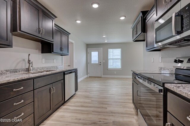 1919 Wisconsin Ave, Joplin, MO 64804 - kitchen with stainless steel appliances, light wood-type flooring, dark brown cabinets, light stone countertops, and recessed lighting
