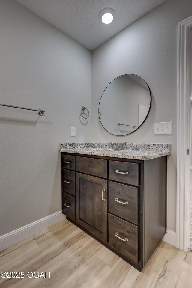 1919 Wisconsin Ave, Joplin, MO 64804 - bathroom featuring wood finished floors, vanity, and a textured ceiling