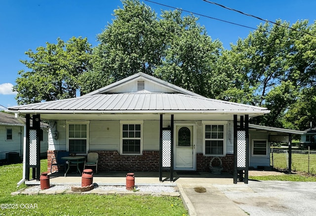 210 S 3 Rd, St, Arma, KS 66712 - view of front facade featuring covered porch, metal roof, and a front yard
