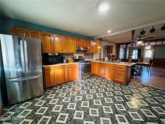 210 S 3 Rd, St, Arma, KS 66712 - kitchen with stainless steel appliances, a peninsula, a textured ceiling, a ceiling fan, and a sink
