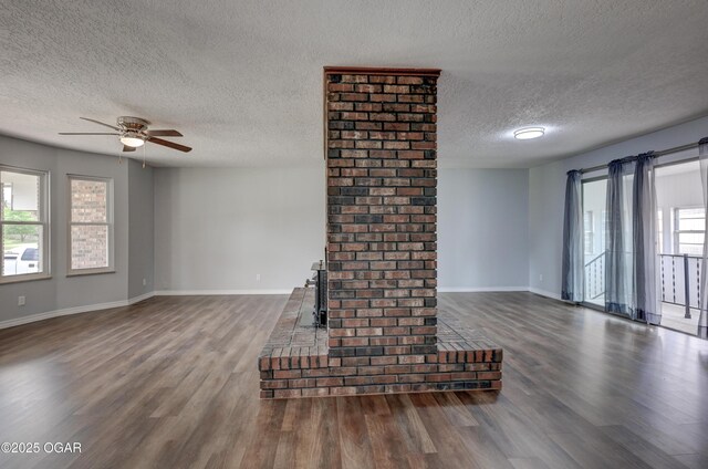 720 Sheridan Ave, Carl Junction, MO 64834 - unfurnished living room featuring a textured ceiling, dark wood-style flooring, baseboards, and ceiling fan