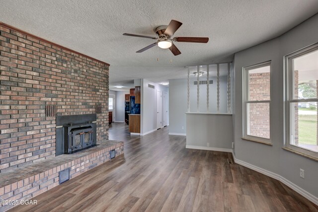 720 Sheridan Ave, Carl Junction, MO 64834 - unfurnished living room with wood finished floors, a textured ceiling, a ceiling fan, and baseboards