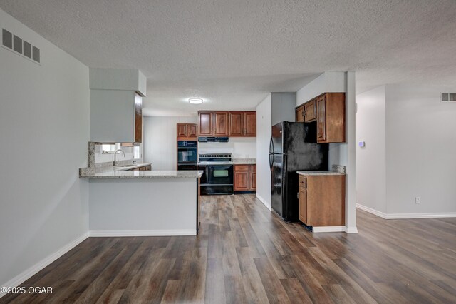 720 Sheridan Ave, Carl Junction, MO 64834 - kitchen with black appliances, a textured ceiling, a sink, under cabinet range hood, and dark wood-type flooring
