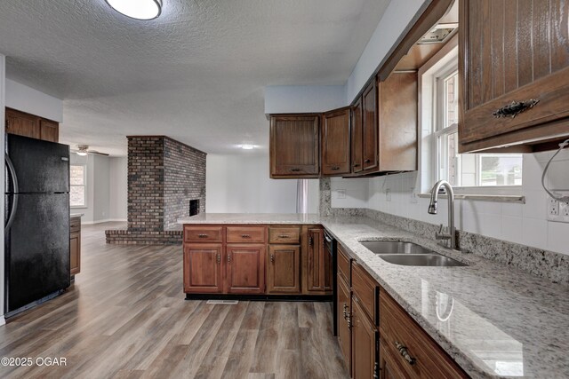 720 Sheridan Ave, Carl Junction, MO 64834 - kitchen with black appliances, a sink, light wood finished floors, a peninsula, and a textured ceiling