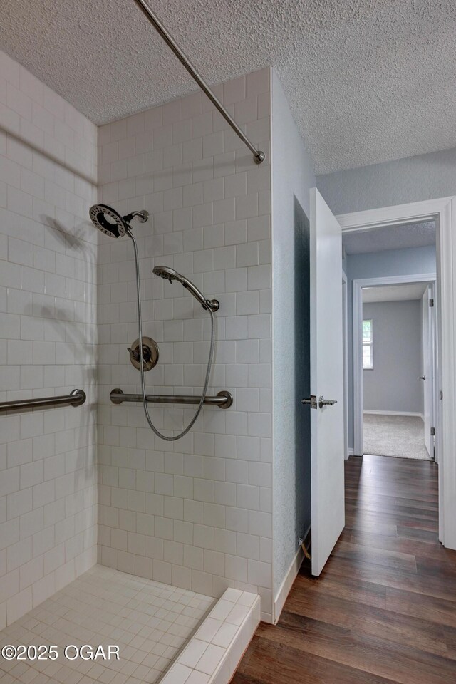720 Sheridan Ave, Carl Junction, MO 64834 - full bath featuring wood finished floors, a shower stall, baseboards, and a textured ceiling