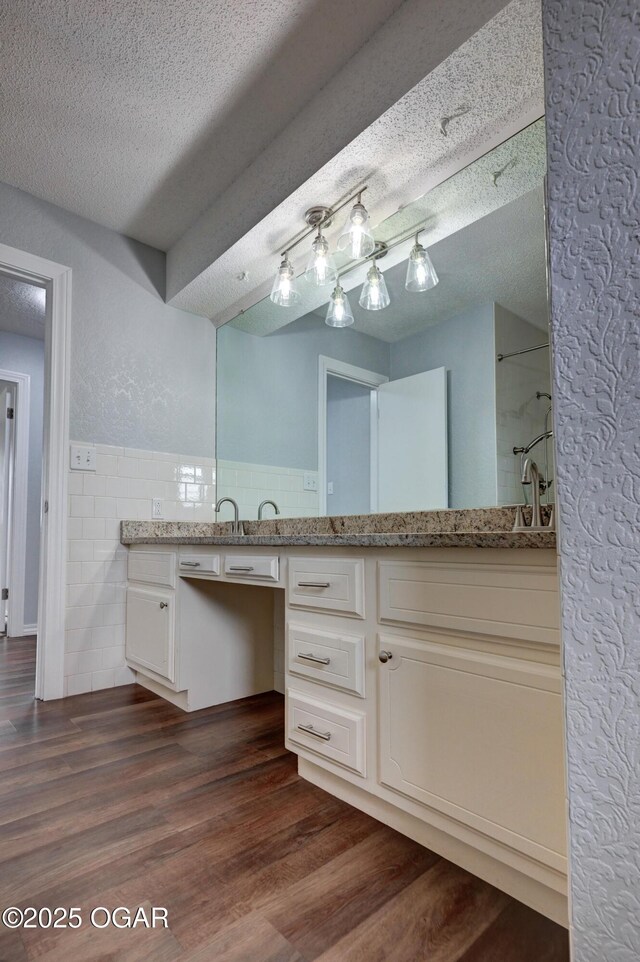 720 Sheridan Ave, Carl Junction, MO 64834 - full bath featuring double vanity, tile walls, a textured ceiling, wood finished floors, and wainscoting