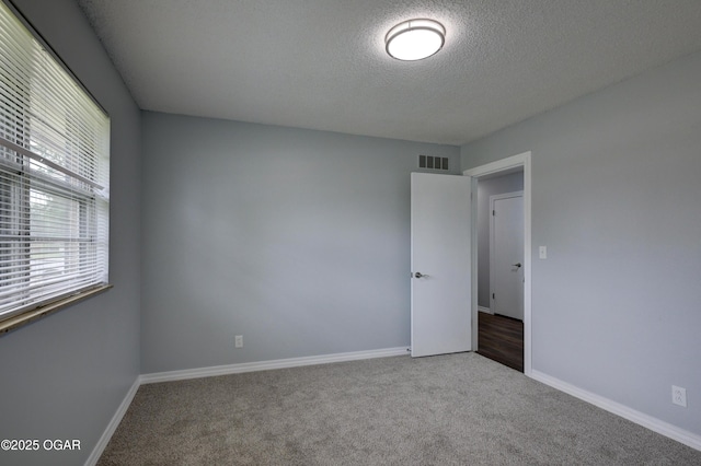 720 Sheridan Ave, Carl Junction, MO 64834 - empty room featuring a textured ceiling, carpet floors, and baseboards