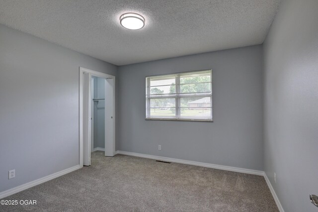 720 Sheridan Ave, Carl Junction, MO 64834 - unfurnished bedroom featuring a textured ceiling, carpet, baseboards, and a closet