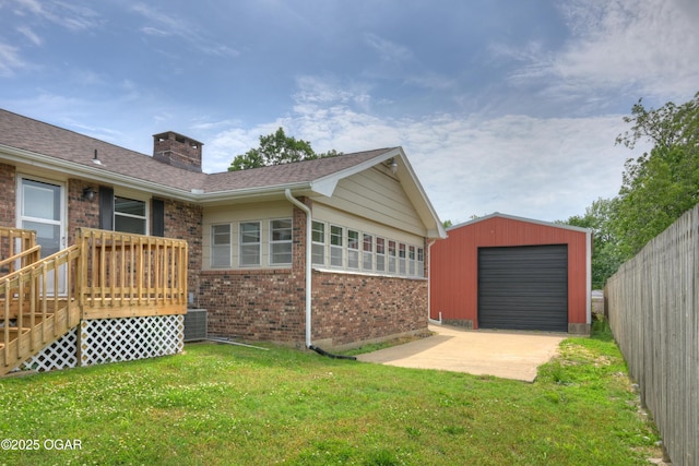 720 Sheridan Ave, Carl Junction, MO 64834 - back of house featuring brick siding, a lawn, a chimney, an outdoor structure, and central AC