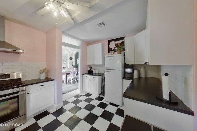2101 N Florida Ave, Joplin, MO 64801 - kitchen featuring gas range, freestanding refrigerator, dark countertops, and wall chimney range hood