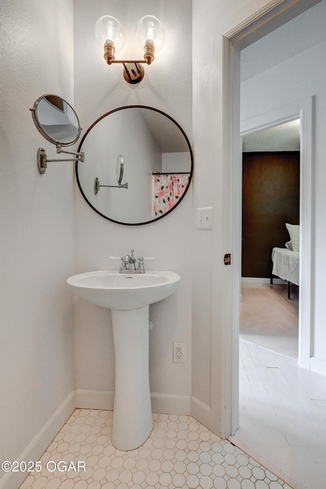 2101 N Florida Ave, Joplin, MO 64801 - ensuite bathroom featuring baseboards and a sink