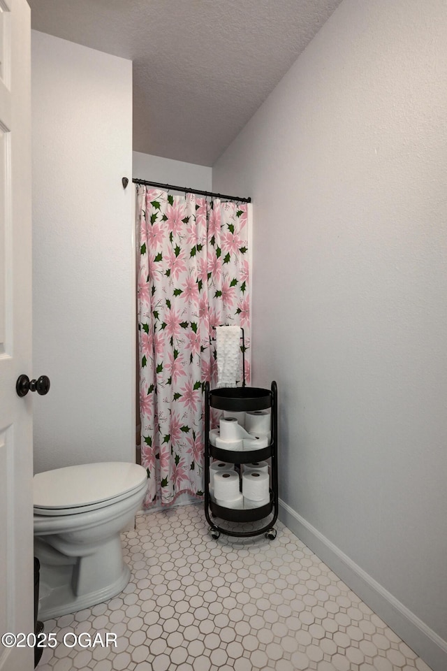 2101 N Florida Ave, Joplin, MO 64801 - bathroom with toilet, baseboards, curtained shower, and a textured ceiling