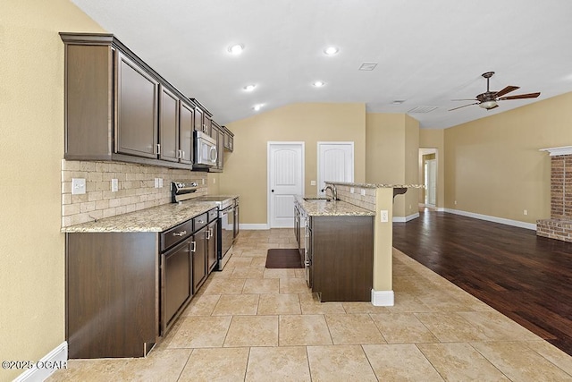 111 Zachary Ln, Carl Junction, MO 64834 - kitchen with appliances with stainless steel finishes, lofted ceiling, a sink, dark brown cabinetry, and recessed lighting