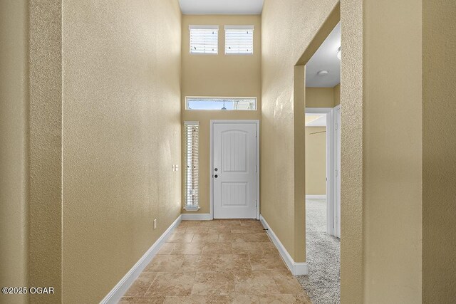 111 Zachary Ln, Carl Junction, MO 64834 - foyer entrance with a textured wall, baseboards, a high ceiling, and stone finish floors
