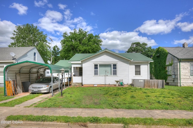 1418 Forest St, Carthage, MO 64836 - view of front of house with a detached carport, a front yard, driveway, metal roof, and crawl space