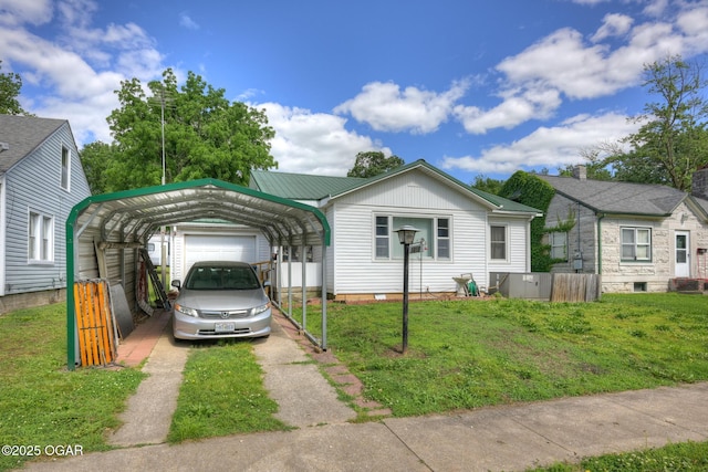 1418 Forest St, Carthage, MO 64836 - view of front facade featuring a detached carport, a front lawn, asphalt driveway, and crawl space