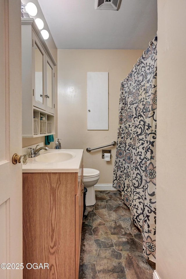 1418 Forest St, Carthage, MO 64836 - bathroom with stone finish floors, vanity, baseboards, and toilet