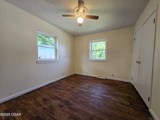 202 S Mckinley Ave, Joplin, MO 64801 - unfurnished bedroom with multiple windows, dark wood-style flooring, baseboards, and a ceiling fan