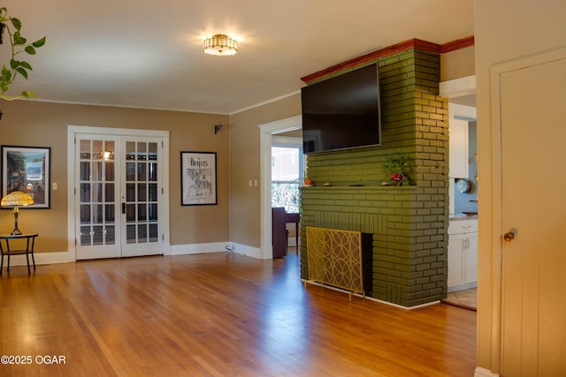 702 W Daugherty St, Webb City, MO 64870 - unfurnished living room featuring light wood-style floors, french doors, baseboards, a brick fireplace, and crown molding