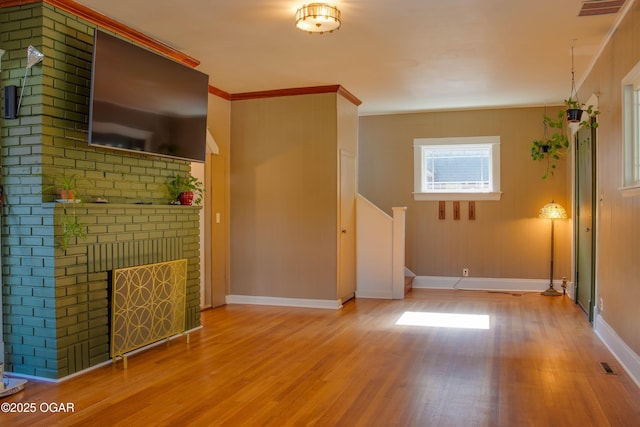 702 W Daugherty St, Webb City, MO 64870 - unfurnished living room featuring wood finished floors, baseboards, stairs, crown molding, and a fireplace