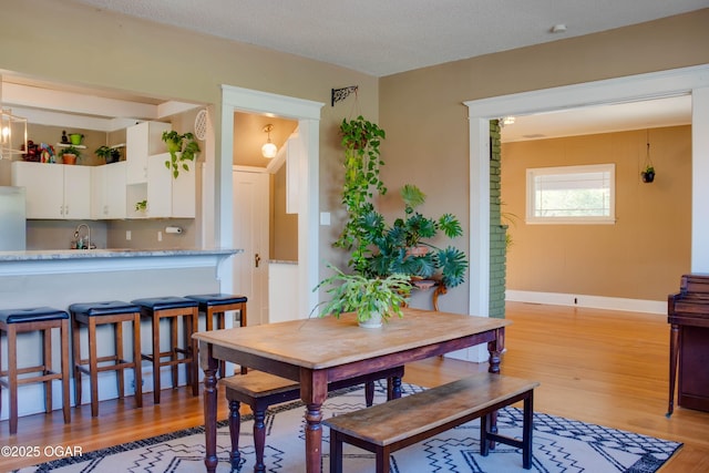 702 W Daugherty St, Webb City, MO 64870 - dining space with light wood-style floors, baseboards, and a textured ceiling