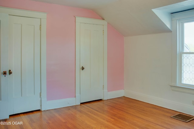 702 W Daugherty St, Webb City, MO 64870 - additional living space featuring light wood-style flooring, vaulted ceiling, baseboards, and plenty of natural light