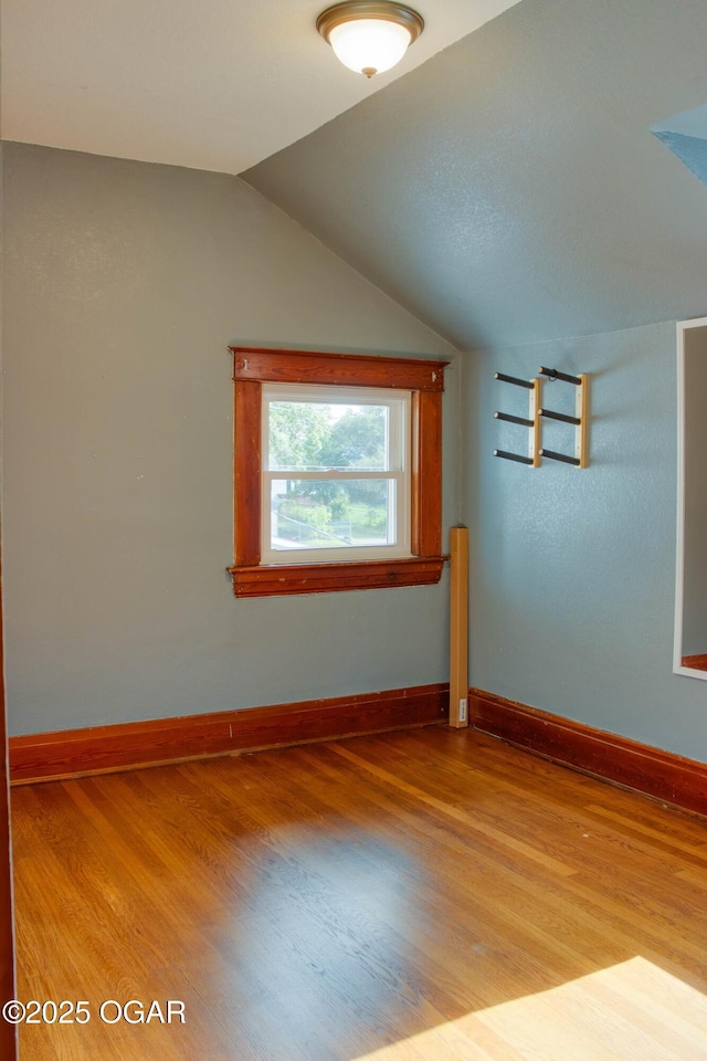 702 W Daugherty St, Webb City, MO 64870 - unfurnished room featuring wood finished floors, lofted ceiling, and baseboards