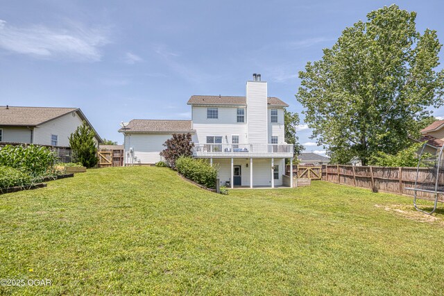 408 W Walton Ave, Carl Junction, MO 64834 - rear view of property with a chimney, a trampoline, and a wooden deck