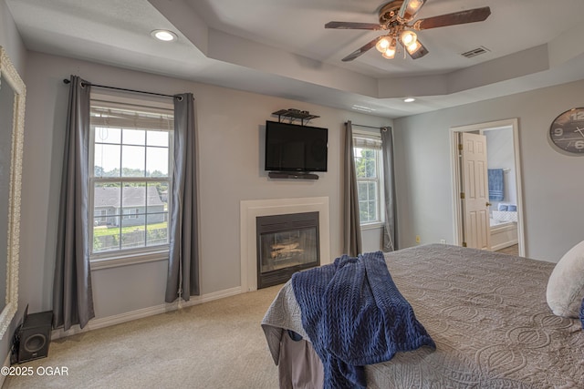 408 W Walton Ave, Carl Junction, MO 64834 - bedroom with light carpet, a tray ceiling, a glass covered fireplace, baseboards, and recessed lighting