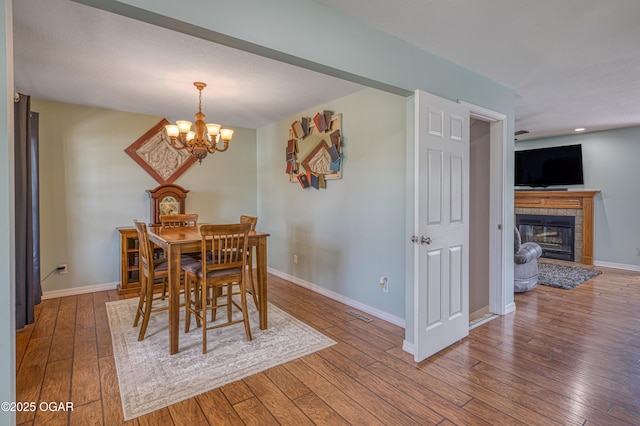 408 W Walton Ave, Carl Junction, MO 64834 - dining area with wood-type flooring, a chandelier, baseboards, a glass covered fireplace, and recessed lighting