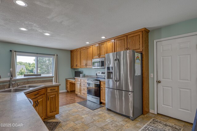 408 W Walton Ave, Carl Junction, MO 64834 - kitchen featuring appliances with stainless steel finishes, a sink, stone tile flooring, baseboards, and recessed lighting