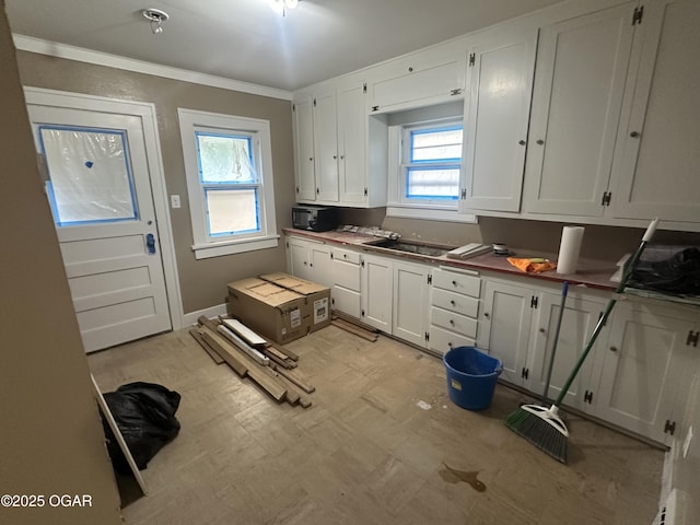 206 S Connor Ave, Joplin, MO 64801 - kitchen featuring light flooring, plenty of natural light, white cabinetry, ornamental molding, and a sink