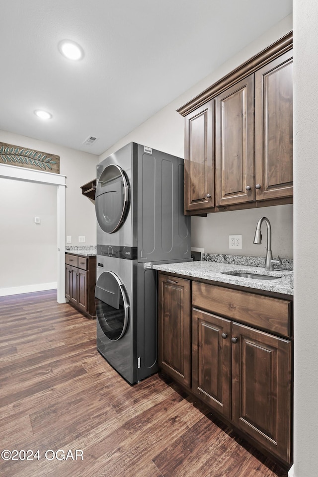 216 Timber Trail Dr, Joplin, MO 64804 - washroom with stacked washing machine and dryer, cabinet space, dark wood-style floors, and recessed lighting