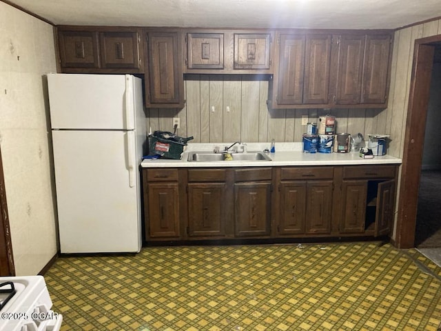 205 S Mccoy Ave, Joplin, MO 64801 - kitchen with white appliances, light countertops, wood walls, dark brown cabinetry, and light floors