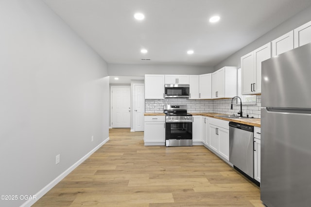 504 S Mckinley Ave, Joplin, MO 64801 - kitchen featuring wood counters, appliances with stainless steel finishes, a sink, backsplash, and recessed lighting
