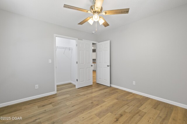 504 S Mckinley Ave, Joplin, MO 64801 - unfurnished bedroom featuring baseboards, light wood-style floors, a closet, and a walk in closet