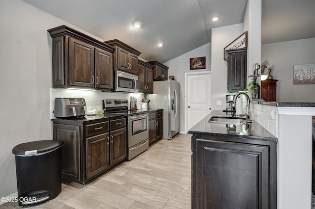 1692 Betenbough Way, Webb City, MO 64870 - kitchen with appliances with stainless steel finishes, a sink, dark countertops, dark brown cabinetry, and lofted ceiling