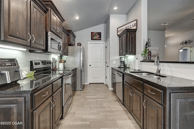 1692 Betenbough Way, Webb City, MO 64870 - kitchen featuring appliances with stainless steel finishes, a sink, dark brown cabinets, a peninsula, and decorative backsplash
