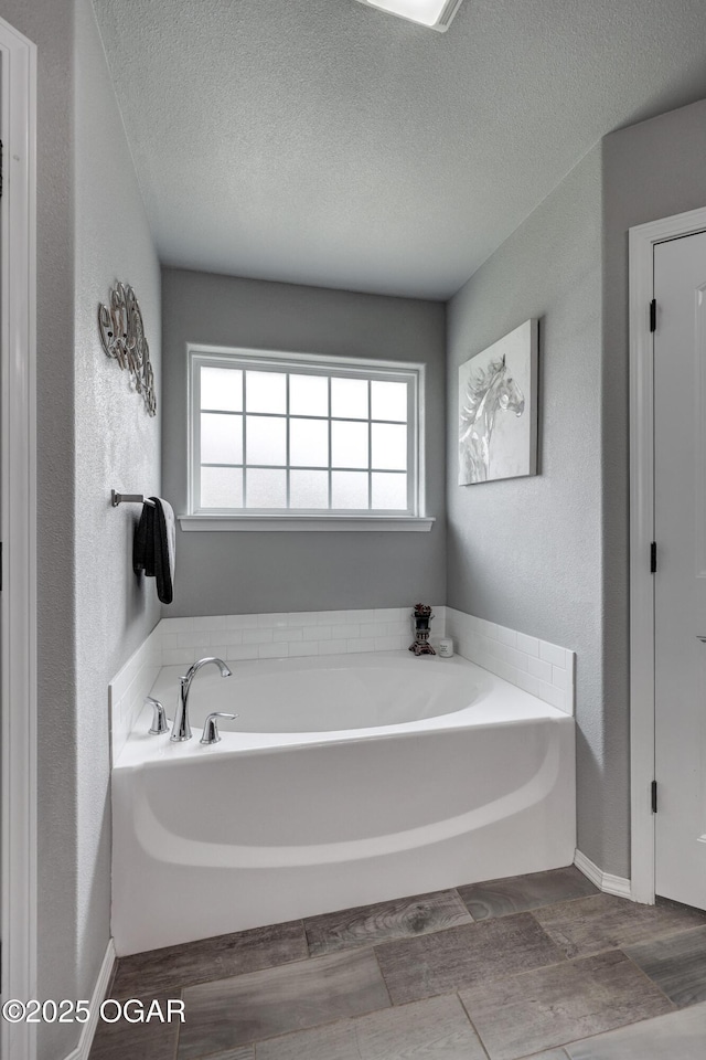 1692 Betenbough Way, Webb City, MO 64870 - bathroom with a bath, a textured ceiling, wood finished floors, and baseboards