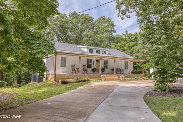 2010 Cherry St, Seneca, MO 64865 - view of front of house featuring a porch, roof with shingles, a front yard, driveway, and central AC unit