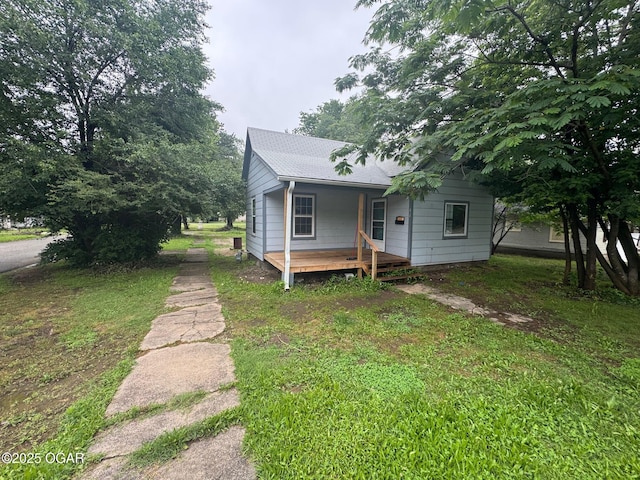 404 E 18th St, Baxter Springs, KS 66713 - view of front of home featuring a porch, roof with shingles, and a front yard