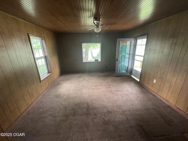 404 E 18th St, Baxter Springs, KS 66713 - unfurnished room featuring plenty of natural light, carpet flooring, a ceiling fan, wood walls, and wooden ceiling