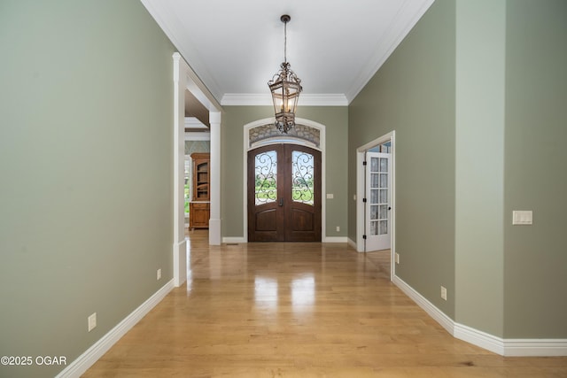 1704 Liam St, Carthage, MO 64836 - foyer entrance featuring a chandelier, french doors, ornamental molding, light wood finished floors, and baseboards